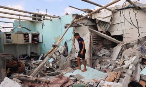A Palestinian boy looks at the remains of a house hit by Israeli bombardment