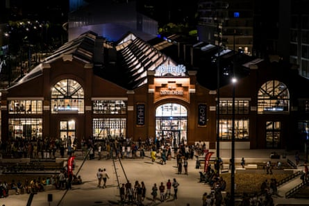 Exterior shot, at night, of Les Halles de la Cartoucherie, which opened in Toulouse in September 2023 and which is a food hall and co-working space.