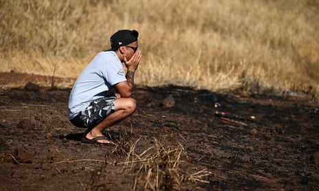 Maui resident John Rey Serrano reacts while looking from a road above Lahaina Town in the aftermath of a wildfire in Lahaina, western Maui, Hawaii on August 11, 2023.