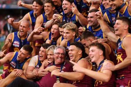 Lions players and Chris Fagan pose for a group photo after being presented with the premiership medals and cup