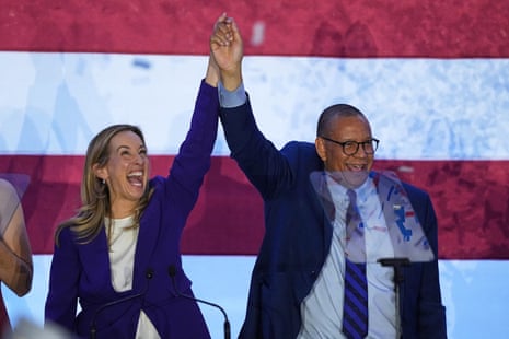 Mikie Sherrill and Dale Caldwell standing side by side, hands interlaced and raised, both smiling.