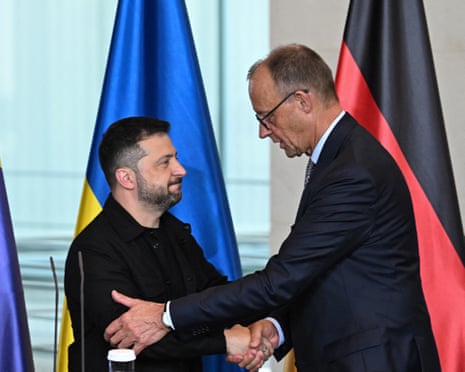Ukrainian President Volodymyr Zelenskyy (L) and German Chancellor Friedrich Merz (R) shake hands after addressing a joint press conference in August.