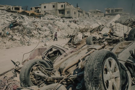 People walk through the ruins of their town