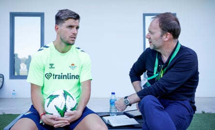 Lowe and Lo Celso sit on a bench next to the training pitch and talk