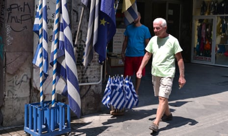 A man walks past greek flags for sale in central Athens on 11 August.