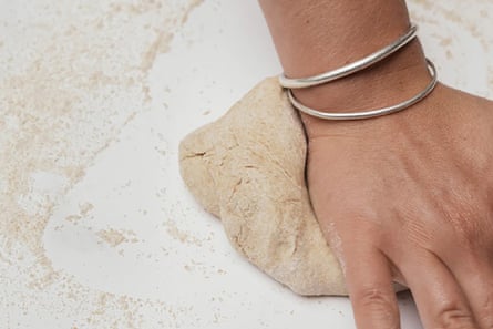 Primo piano di una mano che impasta un mucchio di pasta