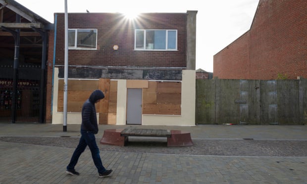 A man walks past shuttered buildings in Barrow-in-Furness