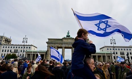 Israel-Hamas war live: White House promises ‘continued flow’ of Gaza aid as Israel steps up airstrikes in north of strip | Israel-Hamas war 3 Demonstrators wave Israeli flags in front of the Brandenburg Gate in Berlin.