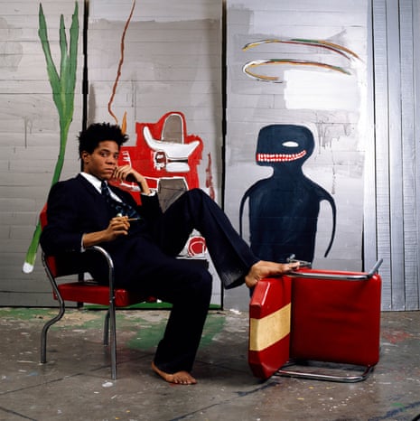 Jean-Michel Basquiat wearing Giorgio Armani, seating in front of his work.