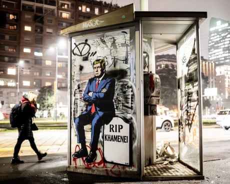 Graffiti in Milan in a main road at night depicts Donald Trump sitting on a tombstone with the inscription 'Rip Khamenei'.