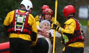 Members of the emergency services evacuate residents from flooded houses after the River Taff burst its banks in Nantgarw, in south Wales.