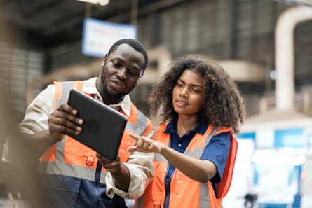 Woman pointing to a computer on a building site