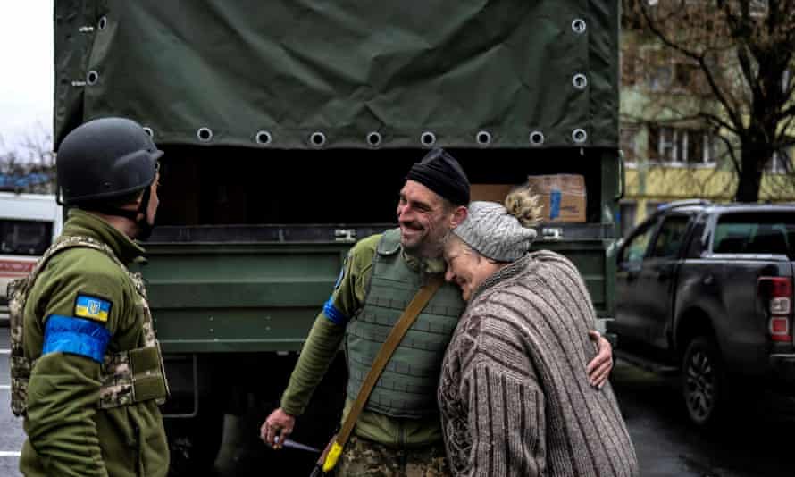 An elderly woman embraces a Ukrainian soldier in Bucha
