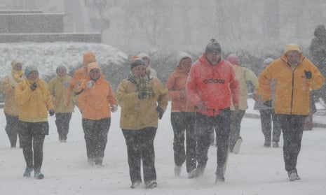 No pay-in, no gain: people exercise at a park amid a snow flurry in central Kiev.