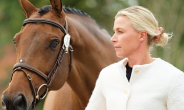 Georgie Campbell standing alongside her horse Global Quest for a pre-competition inspection at an event in the Netherlands in October 2023; it is a head-and-shoulders view of them in which she has her blond hair tied back and she is wearing a pale cream cardigan; the dark bay horse wears his bridle and has his black mane plaited into tight knots as for formal competition but is unsaddled.