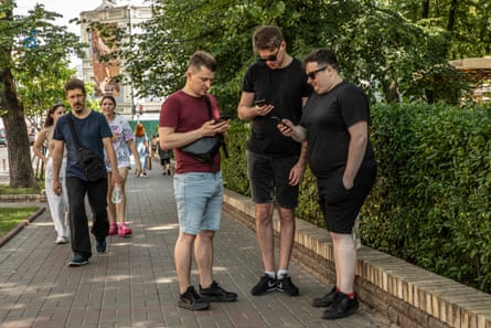 Young men look at their mobile phone screens