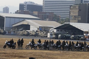 Military personnel loyal to President Maduro wait inside La Carlota airbase