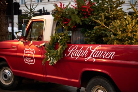 A red pick up truck with the words Ralph Lauren on the side of it transports Christmas trees.