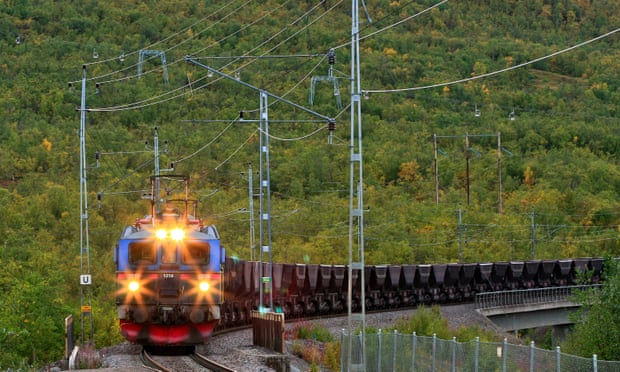 View of an Electrical Ore Line Train in speed comes in. Autumn, and lights on.
