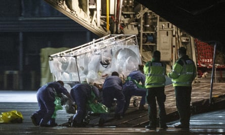 Medical personnel wheel a quarantine tent trolley containing Scottish healthcare worker Pauline Cafferkey after returning to Scotland from Sierra Leone, into a plane at Glasgow International Airport.