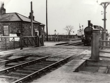 black and white photograph of train outside station