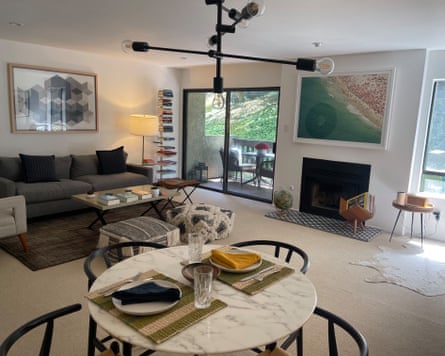A well-designed room with a fireplace, tables and sofa, pictures on the wall and a balcony.