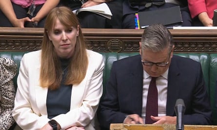 Starmer looks at his notes while sat next to Rayner on the front bench in parliament