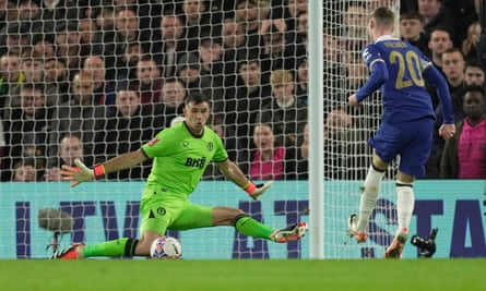 Aston Villa's goalkeeper Emiliano Martínez makes a save from Chelsea's Cole Palmer.