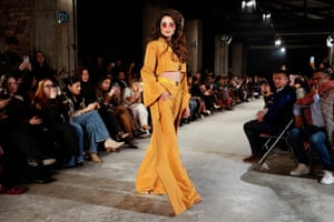 A model walks the runway wearing a mustard yellow haute couture outfit