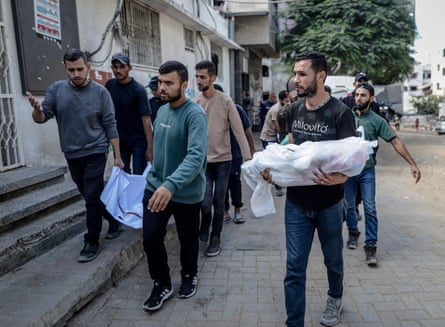 Men carrying small white shrouds