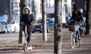 A woman rides an electric scooter wearing a protective mask, amid the continuous spread of the coronavirus pandemic, along Standvagen in Stockholm, Sweden, 20 November 2020.