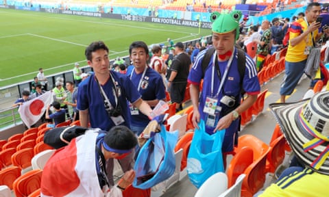 Japanese supporters clean the stand after their match with Colombia.