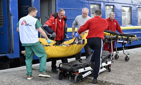 Ambulance workers and MSF medics transfer a patient to an ambulance in Lviv.