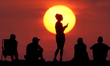 18 de julio La gente sale a ver el amanecer en Cullercoats Bay, North Tyneside el día en que las temperaturas se dispararon
