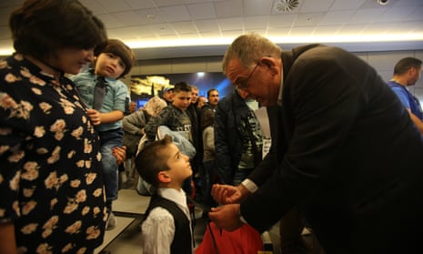 Ioannis Mouzalas talks to a refugee child at Athens international airport last month