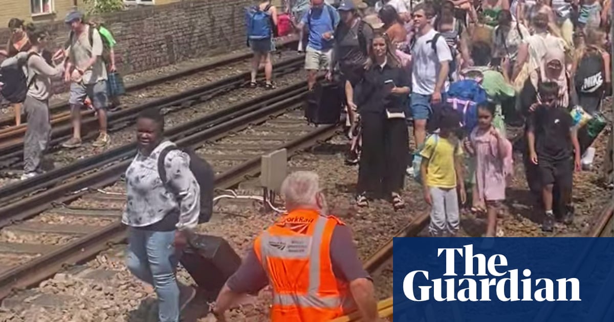 Evacuated London train passengers forced to walk along tracks on hottest day of year | Rail transport Evacuated London train passengers forced to walk along tracks on hottest day of year | Rail transport