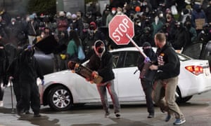 Protesters chase a street preacher, right, who was using a loudspeaker to deliver a sermon during a protest against police brutality in downtown Tacoma.