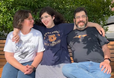 A family of three sitting on a bench