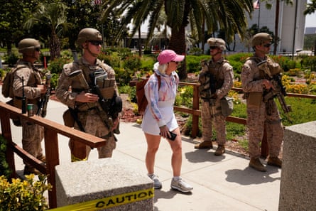 four armed people in military uniform and a person in summer clothes