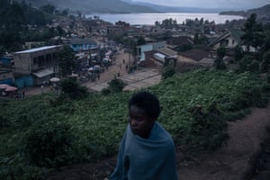 A war-displaced woman walks near to a church where more than 200 families have taken refuge in the centre of Minova, DRC