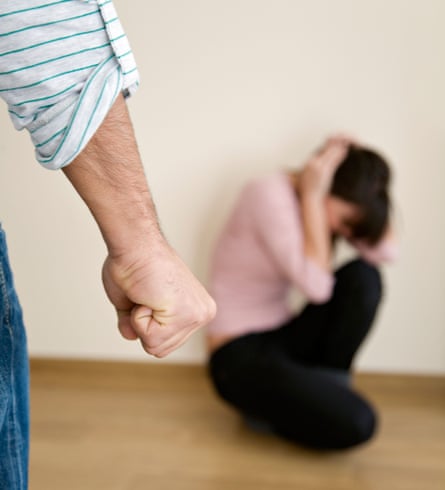 Man with clenched fist close to woman kneeling in backdrop.