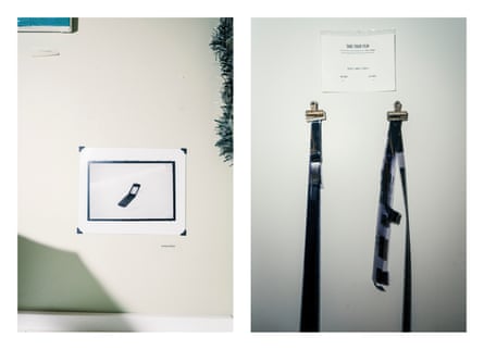 Student artwork of a flip phone hangs on a wall, and film hangs to dry in a photography class at Buxton school.