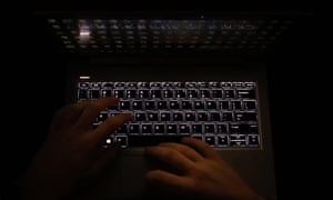 Hands on an illuminated keyboard typing
