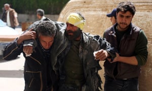 Syrians help a man, wounded during government airstrikes in Deir al-Asafir.