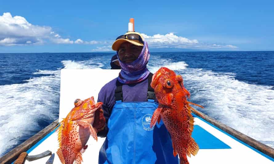 Walter Borbor, a small-scale fisherman, holds his catch of scorpion fish, or brujo. He must make longer fishing trips for smaller catches as he competes with huge facotry ships near the Galápagos marine reserve.