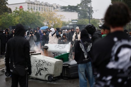 Masked protesters gather around a barricade
