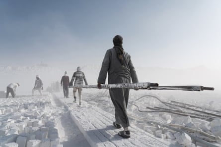عمال يسيرون في محجر الحجر الجيري في المنيا، مصر، مع الآلات المستخدمة لقطع الحجر الجيري.