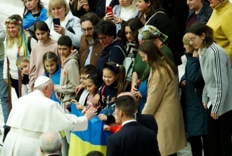 Pope Francis greets children holding up a Ukrainian flag during today’s weekly general audience at the Vatican.