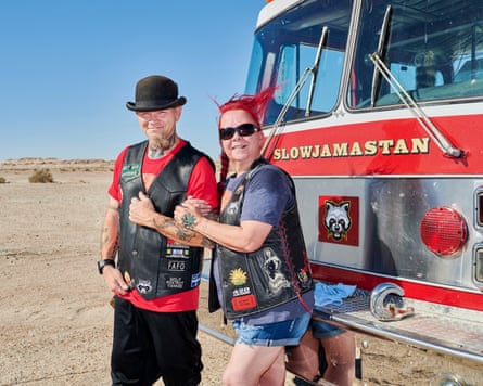 man and woman in front of a red truck reading slowjamastan