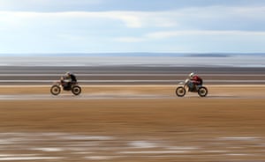 Two riders make their way down the beach